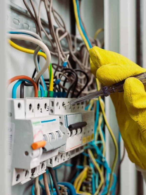 Selective focus of electrician using screwdriver while fixing electric panel